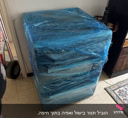 שידה עטופה בניילון כחול למעבר דירה